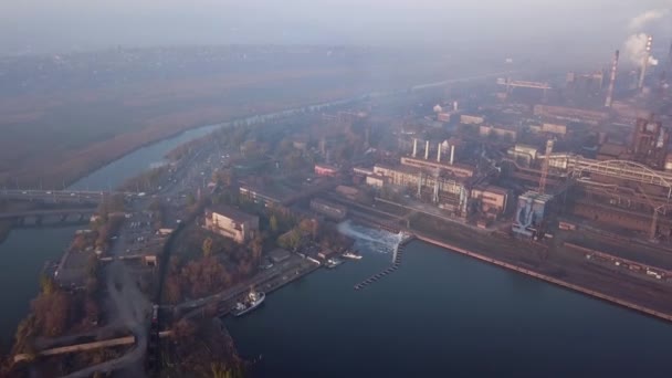 Aerial of industrial city with air atmosphere and river water pollution from metallurgical plant and blast furnaces near sea. Dirty smoke, smog from pipes of steel factory. Ecological issues concept. — Stockvideo