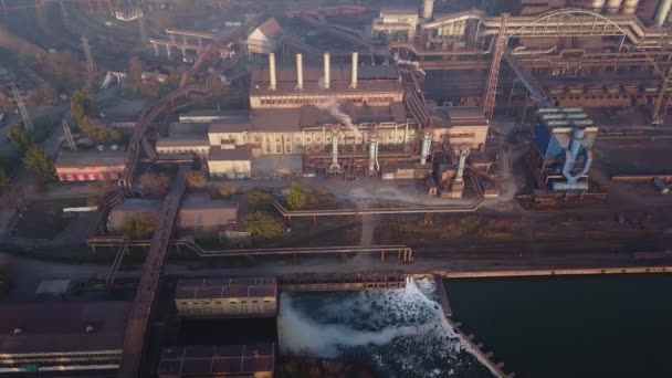 Flygfoto av industristad med luft- och flodvattenföroreningar från metallverk och masugnar nära havet. Smutsig rök, smog från stålrör. Begreppet ekologiska frågor. — Stockvideo