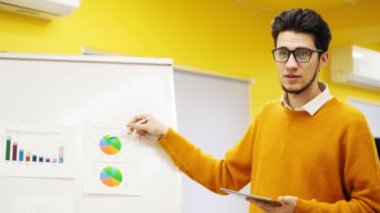 İş adamı antrenörü bir rapor sunar, konferans salonundaki çizelgelerde şemaları gösterir. Proje yöneticisi ofiste sunumla ilgili soruları tartışıyor. Usta sınıftan izleyiciye öğretmen.