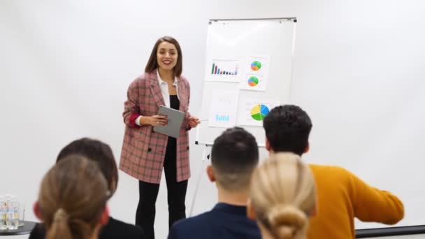Business Woman Coach Trainer Presents Report Shows Diagrams Flip Chart — Stock Video