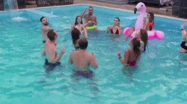 Arkadaşların özel bir yüzme havuzunda gece havuzu partisi var. Mayolu mutlu gençler su sıçratır, şamandıralarla dans eder ve lüks bir tatil köyünde şişme yatak giyer..