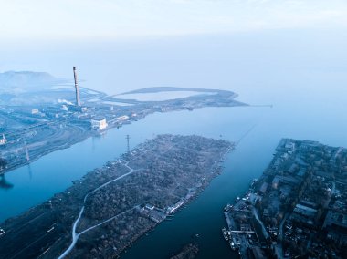 Metalurjik santralden kaynaklanan hava ve su kirliliği ve deniz limanı yakınlarındaki fırınlarla dolu bir sanayi şehri. Kirli duman, çelik fabrikasının borularından çıkan duman. Ekolojik konular kavramı.