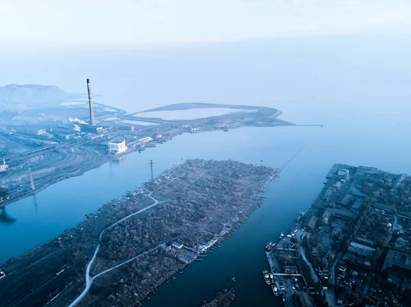Metalurjik santralden kaynaklanan hava ve su kirliliği ve deniz limanı yakınlarındaki fırınlarla dolu bir sanayi şehri. Kirli duman, çelik fabrikasının borularından çıkan duman. Ekolojik konular kavramı.