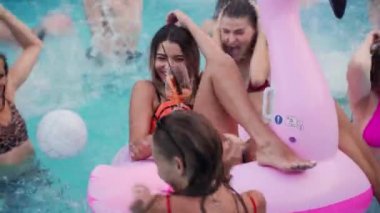 Arkadaşların özel bir yüzme havuzunda gece havuzu partisi var. Mayolu mutlu gençler su sıçratır, şamandıralarla dans eder ve lüks bir tatil köyünde şişme yatak giyer..