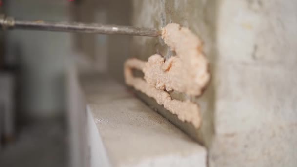 承包商应用聚氨酯泡沫粘合剂与枪在混凝土墙上粘贴高压充气混凝土砖 工人喷洒聚氨酯泡沫 孤立的观点 — 图库视频影像