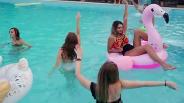 Arkadaşların özel bir yüzme havuzunda gece havuzu partisi var. Mayolu mutlu gençler su sıçratır, şamandıralarla dans eder ve lüks bir tatil köyünde şişme yatak giyer..