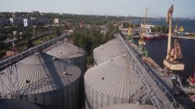 Deniz limanındaki modern tahıl asansörü terminali. Metal tanklar ve tahıl kurutma makineleri limandaki karmaşık siloları idare ediyor. Buğday bir yük konteynırına yükleniyor. Sevkiyat ve ulaşım.