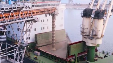 Limandaki deniz tahıl terminalindeki yük konteynırına buğday yükleme. Buğday sevkiyatı, ambardan büyük bir gemiye, deniz limanındaki sandık yoluyla. Tarım ürünlerinin nakliyesi..