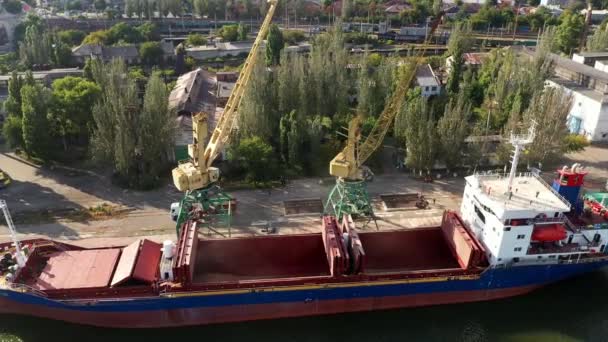 コンテナから貨物船への穀物輸送は 海上港のガントリークレーン上のデュアルスクープクラムシェルグラブを保持しています 水輸送付きダンプトラックからの小麦の出荷 商品輸送 — ストック動画