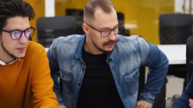 Bir grup ofis çalışanı toplantı odasında başlangıç projesini tartışıyor. İş ortaklarından oluşan bir ekip müzakerelerde etkileşime geçiyor. Kurumsal insanlar tartışarak konuşur. Üniversite öğrencileri.