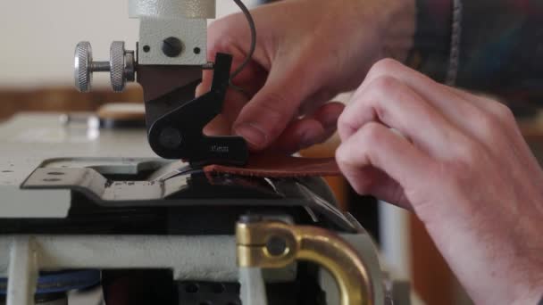 皮革工匠在他的车间工作 主要生产皮革制品 电动皮革跳板薄化机或工业扁平铲切割机工作的人 用厚量计测量 — 图库视频影像