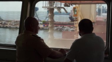 2021-06-09 Mariupol, Ukrayna. Ukrtransagro LLC. Gemi kaptanı ve nakliye acentesi buğday yükleme noktasından bir limana bakıyor..