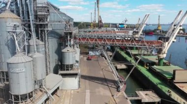 2021-06-09 Mariupol, Ukrayna. Ukrtransagro LLC. Limandaki deniz tahıl asansöründeki yük ambarına tahıl havası yükleniyor. Buğday sevkiyatı, liman terminalindeki bir sandıktan büyük bir gemiye.