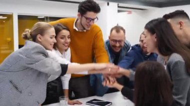İş adamları toplantı masasının üstüne el ele tutuşup şirket kurma etkinliğinde tezahürat yapıyorlar. İş arkadaşları yardım eder, takım çalışmasını destekler. Birlik konsepti. Meslektaşlar başarıyı kutlamak için birleşir.