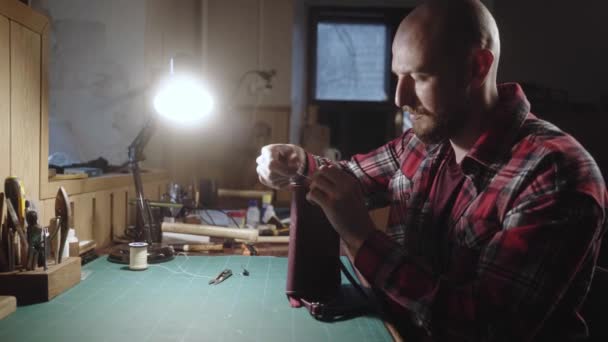 皮革工匠制作手提包 有针线的人在皮革车间工作 裁缝师穿着格子呢衬衫 用正宗的工作室做钱包缝纫配件 — 图库视频影像