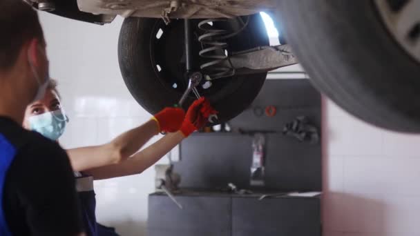 Kraftfull Kvinna Mekaniker Reparera Bils Löpverk Träna Manlig Praktikant Kvinnlig — Stockvideo