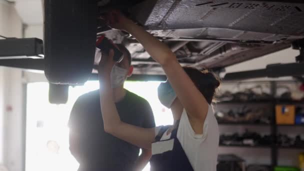 Kvinnlig Mekaniker Inspekterar Bilens Fjädring Stark Kvinna Som Coachar Manlig — Stockvideo