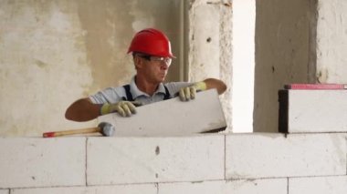 Tuğlacı ya da duvar ustası otoklastlı beton bloklardan duvar inşa etmek için tuğla döşüyorlar. Tuğla işçiliği müteahhidi inşaat sahasında inşaat işi yapan köpük betonla blok çalışması yapar..
