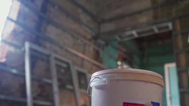 建設現場の女性画家は 塗料バケツの蓋を開きます 若い女性がアパートの改装をしてる 修復と建設作業 — ストック動画