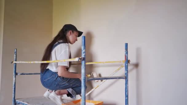 Professionelle Malerin Malt Die Wand Mit Walze Auf Baugerüsten Junge — Stockvideo