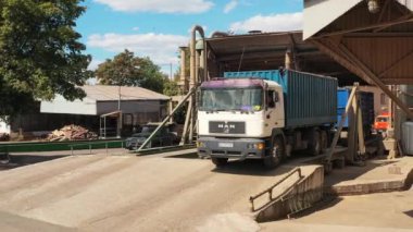 2021-06-09 Mariupol, Ukrayna. Ukrtransagro LLC. Tahıl kamyonu, deniz limanındaki tahıl asansöründe hidrolik yükleyiciyi yükselterek uzaklaşıyor. Tarım malları taşımacılığı ve sevkiyatı.