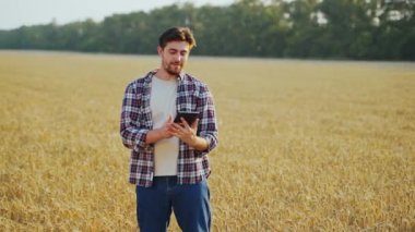Hassas, akıllı çiftçilik. Çiftçi buğday tarlasında online veri yönetim yazılımı kullanarak tablet tutuyor. Dokunmatik bilgisayar, kontrol ve tarım işleriyle uğraşan bir tarımcı. Yenilikçi teknoloji.