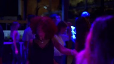 Mariupol, Ukrayna - 25 Temmuz 2021. Hafta sonu partisinde Barbaris gece kulübünde dans eden bir kadın. Disko etkinliğinde çekici kız dansı. İnsanlar diskotekte parti veriyor. Şov lambalarıyla aydınlatılıyor..