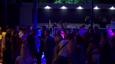 Mariupol, Ukrayna - 25 Temmuz 2021. Barbaris gece kulübünde insanlar dans ediyor ve tezahürat yapıyor. Dans pistinde parti yapan kadın ve erkeklerin siluetleri..