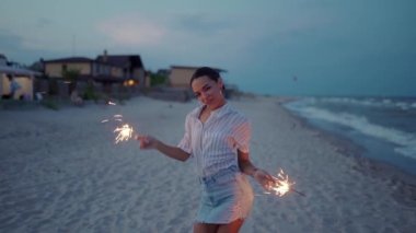 Afrika kökenli Amerikalı bir kadın yürüyor, dans ediyor, sahildeki gece partisinde eğleniyor. 4 Temmuz 'da ellerinde maytap ışığı var. Güzel kız Noel 'de, yeni yılda kumsalda havai fişeklerle parti yapıyor..