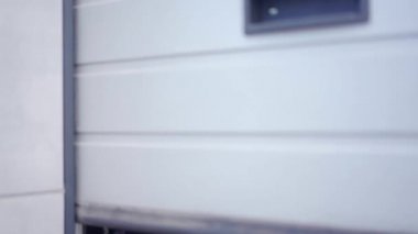 Mutlu kadın araba tamircisi dikey asansör bölüm garaj kapısını açıyor. Araba tamir istasyonunun kapısı yeni bir güne bakıyor ve gülümsüyor. Güçlü profesyonel araba ustası güne başlıyor..
