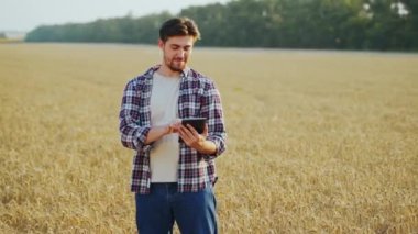 Hassas, akıllı çiftçilik. Çiftçi buğday tarlasında online veri yönetim yazılımı kullanarak tablet tutuyor. Dokunmatik bilgisayar, kontrol ve tarım işleriyle uğraşan bir tarımcı. Yenilikçi teknoloji.