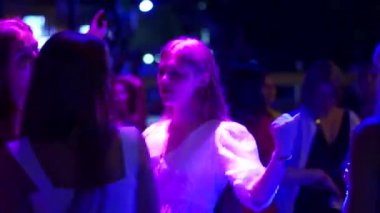 Mariupol, Ukrayna - 25 Temmuz 2021. Hafta sonu partisinde Barbaris gece kulübünde dans eden bir kadın. Disko etkinliğinde çekici kız dansı. İnsanlar diskotekte parti veriyor. Şov lambalarıyla aydınlatılıyor..
