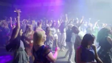 Mariupol, Ukrayna - 25 Temmuz 2021. Barbaris gece kulübünde insanlar dans ediyor ve tezahürat yapıyor. Dans pistinde parti yapan kadın ve erkeklerin siluetleri..