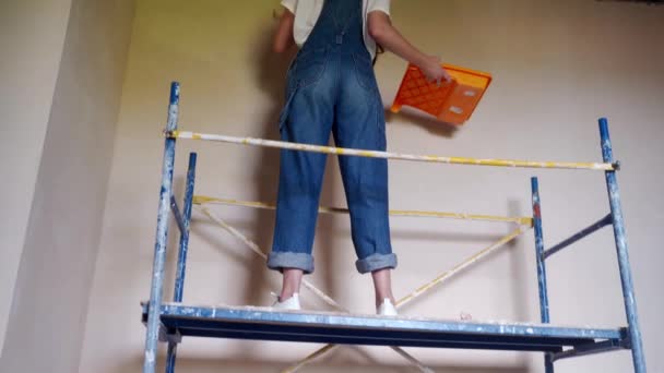 Pintora Profesional Pinta Pared Con Rodillo Andamio Sitio Construcción Mujer — Vídeos de Stock
