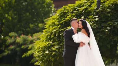 Gelin ve damat lüks malikane avlusunda parkta öpüşürler. Siyah klas takım elbiseli bir adam ve saray bahçesinde duran beyaz elbiseli bir kadın. Düğün mekanında yeni evliler..