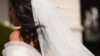 Uzun havadar peçeli, şık beyaz elbiseli güzel gelin düğün günü kameradan kaçıyor. Çekici, oyuncu bir kadın kaçıyor. Arkasını dönüyor, izleyiciye bakıyor. Havada çırpınan kumaş. Beni takip et..