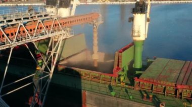 Deniz limanındaki deniz tahıl asansöründe yük ambarına buğday havası yükleniyor. Buğday, terminal limanındaki gövde vasıtasıyla ambardan gövdeye dökülüyor. Tarım ürünlerinin nakliyesi.
