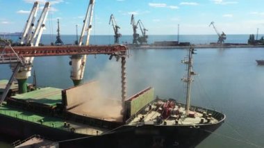 2021-06-09 Mariupol, Ukrayna. Ukrtransagro LLC. Limandaki deniz tahıl asansöründeki yük ambarına tahıl havası yükleniyor. Buğday sevkiyatı, liman terminalindeki bir sandıktan büyük bir gemiye.