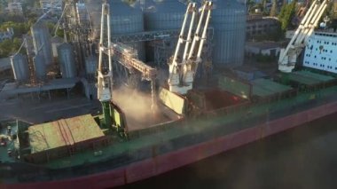 Deniz limanındaki deniz tahıl asansöründe yük ambarına buğday havası yükleniyor. Buğday sevkiyatı. Terminal limanındaki bir sandık vasıtasıyla. Tarım ürünlerinin nakliyesi.