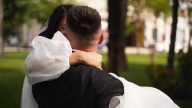 Damat düğün gününde gelinin elini tutuyor. Romantik heyecanlı bir çift yeni evli evliliğin tadını çıkarıyor. Uzun, havadar bir peçe içinde kıvrılan bir kadın. Havada çırpınan kumaşlı zarif bir elbise..