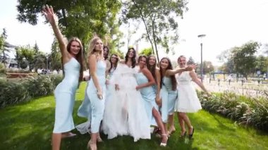 Güzel gelin ve aynı soluk mavi elbiseli güzel nedimeleri parkta tezahürat yapıyor. Beyaz gelinlik partisinde uzun, havalı duvağı olan bir kadın, kız arkadaşlarıyla hava öpücüğü gönderir..