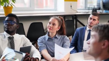 Business woman presents report, shows diagrams, charts in conference room for multiethnic partners. Diverse international team listen CEO on briefing meeting in office. Corporate people discuss plans.