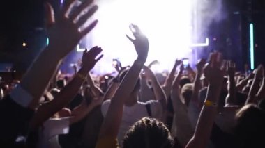 2019-08-09 - Mariupol, Ukraine. MFest festival. People silhouettes waving hands, taking photos or recording videos of live music concert with smartphones at an open air fest. Colorful stage lighting.