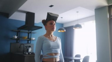 Young doll like pretty woman putting on VR headset standing in minimalistic modern interior. Robot cyber girl avatar enters a metaverse. Virtual reality concept.