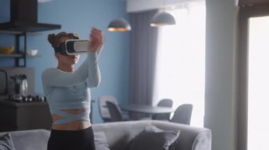Evde sosyal medya platformunda VR kulaklığıyla dans eden gelecekçi kız. Kadın avatarı, takipçileri için metazıt siber uzay dalında deneyimli performans sergiliyor. Kavram.