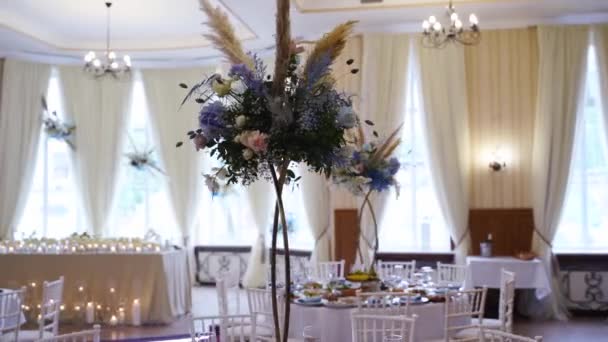ブルー ホワイトバラ 花びら アジサイとレストランホールでの結婚式の装飾花の花束と組成 食卓に並ぶ休日の花々 — ストック動画