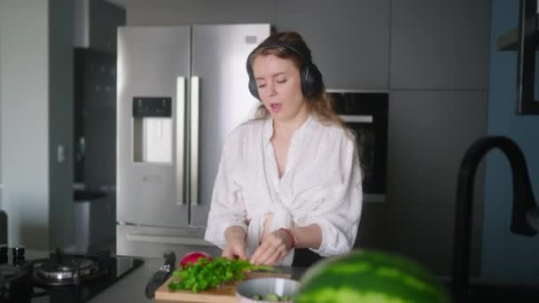 Woman Headphones Making Salad Vegetables Has Fun Dancing Modern Kitchen — Stock Video