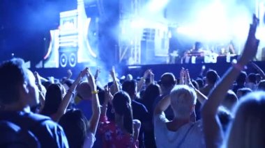 2019-08-09 - Mariupol, Ukraine. MFest festival. People silhouettes clapping, waving hands on live music concert at open air fest. Fans applause at favourite band performance in a slow motion.