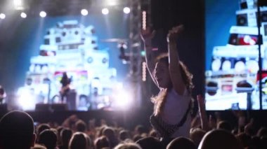 2019-08-09 - Mariupol, Ukraine. MFest festival. Woman sits on boyfriend shoulders, dance waving hands at music concert on open air fest. Crowd jump, applause, enjoy favourite band performance on stage
