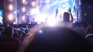 2019-08-09 - Mariupol, Ukraine. MFest festival. Woman sits on boyfriend shoulders, dance waving hands at music concert on open air fest. Crowd jump, applause, enjoy favourite band performance on stage
